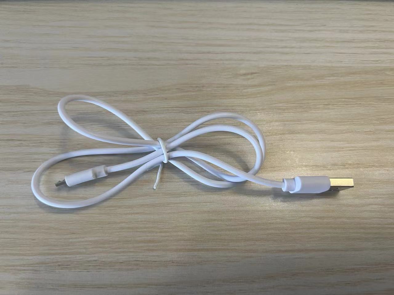 White USB cable on a wooden surface